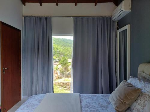 弗洛里亚诺波利斯Casa praia do Forte的一间卧室设有一张床和一个大窗户