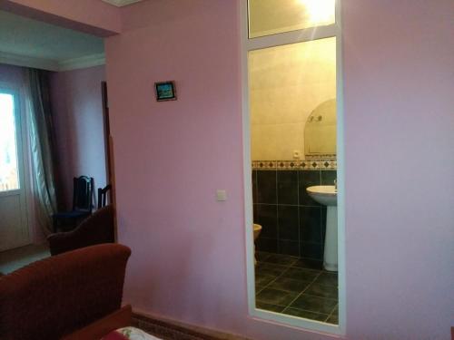 乌雷基HOTEL - SHORENA的浴室设有粉红色的墙壁、水槽和镜子