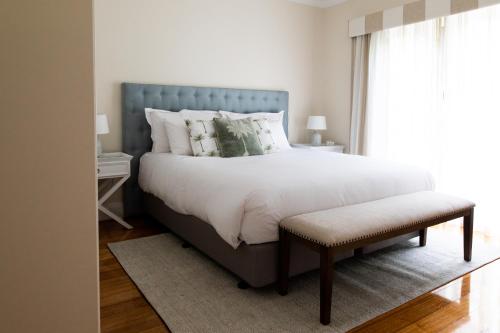 LymingtonWoodland Bay Retreat-Luxury Hamptons Retreat的一间卧室配有一张大床和蓝色床头板