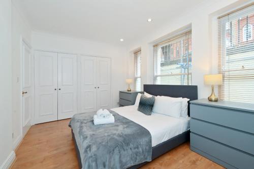 伦敦London Choice Apartments - Gloucester Road - Kensington的一间卧室配有一张床、梳妆台和窗户。