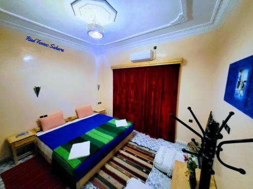 扎古拉Riad Fennec Sahara的一间卧室配有床和红色窗帘
