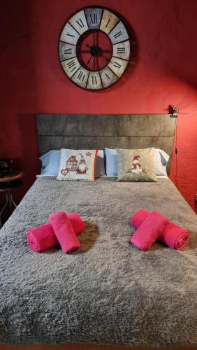 圣胡斯托德斯韦尔恩Estudi Suite Desvern的床上方的大钟,带粉红色毛巾