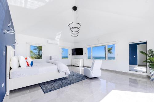 Long PathLovely 4-Bed Villa in Anguilla的一间白色卧室,配有床和电视