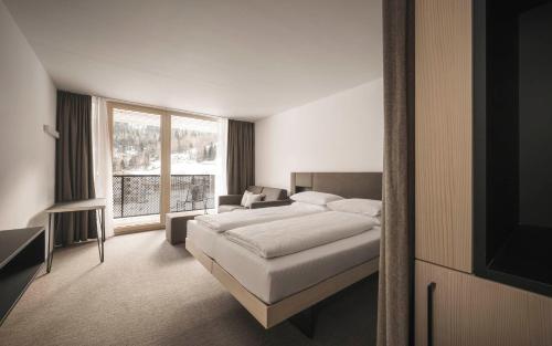 索尔登Sportlers Lodge Sölden lifestyle-lässig-anders的一间卧室设有一张床和一个大窗户