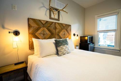 丹佛Enchanting Escape的一间卧室配有一张大床和木制床头板