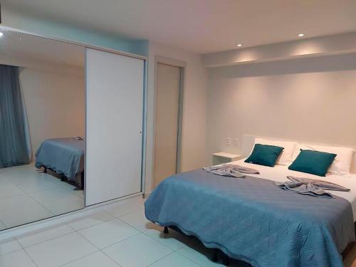 康德Flat Frente Mar - Praia de Tabatinga的一间卧室配有一张床和一面大镜子