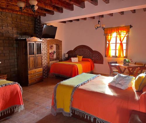 卡尔波镇Hotel El Aguila的一间卧室设有两张床和窗户。