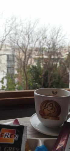 伊斯坦布尔NarPera Taksim Boutique Hotel的坐在窗边的桌子上喝杯咖啡