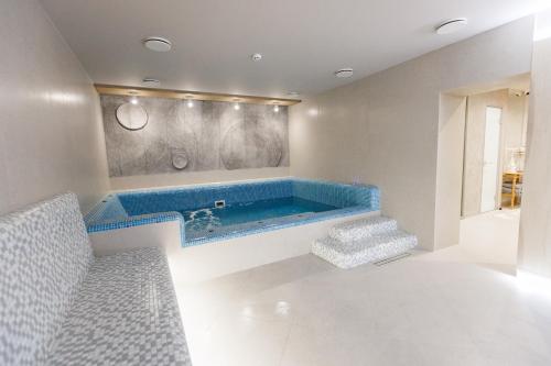 布克维Forest Hill Hotel & SPA的一间客房内的蓝色浴缸浴室