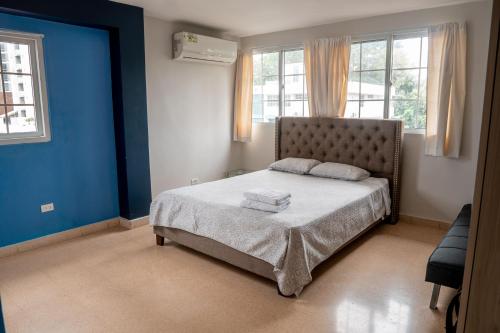巴拿马城Blu Hostel的一间卧室配有一张蓝色墙壁和窗户的床