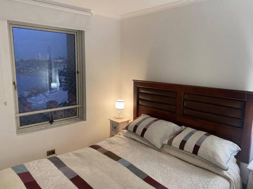 康康Precioso depto vista al mar Concon Condominio Tipo Resort 2 dormitorios的一间卧室设有一张大床和一个窗户。