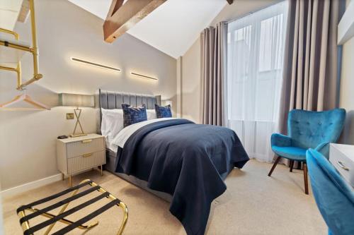 莱斯特NEW Large luxurious 2 bed city penthouse + parking的一间卧室配有一张床和一张蓝色椅子