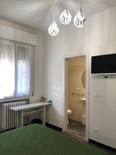 博洛尼亚Dimora Sterlizia zona Fiera S Donato的白色的客房配有书桌和电视。