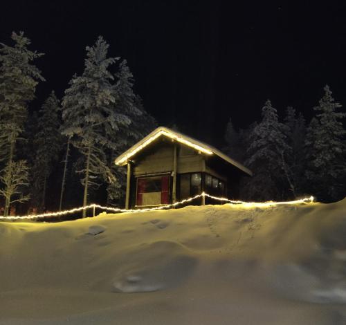 罗瓦涅米Lapland Aurora cabin的小屋在晚上有雪灯