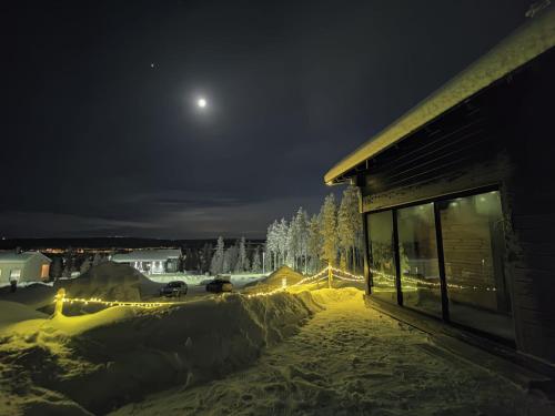 罗瓦涅米Lapland Aurora cabin的雪覆盖的院子的月亮夜景