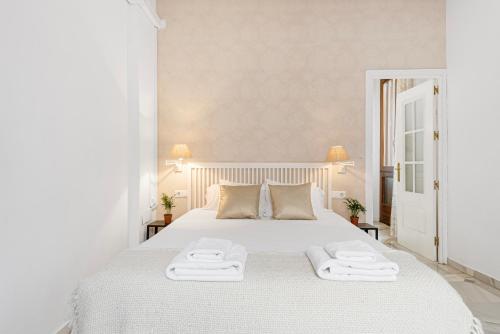 马拉加Pineapple Trinidad Grund Centro的卧室配有白色的床和2条毛巾