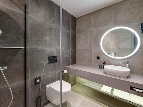 腓特烈港ibis Styles Friedrichshafen的一间带卫生间、水槽和镜子的浴室