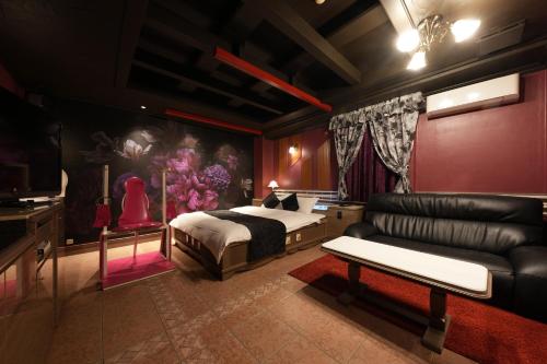 大阪M'SCLUB OsakaHirano AdultOnly的一间卧室配有一张床和一张沙发