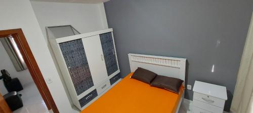 皮乌马Apartamento 204 vista para o mar e piscina的小房间设有橙色的床和镜子