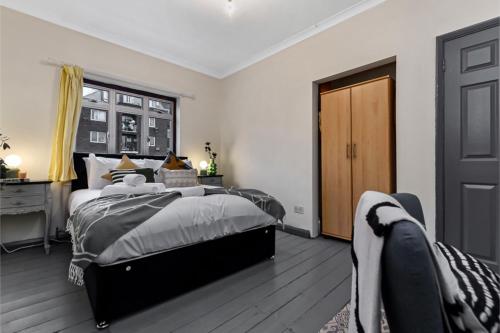 伦敦Charming Family Abode: Beautiful Home with Outdoor Space的一间卧室设有一张大床,铺有木地板