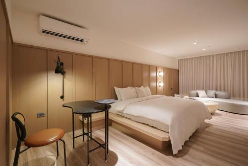 台南Hope Hotel Tainan的酒店客房配有一张床铺、一张桌子和一张书桌。