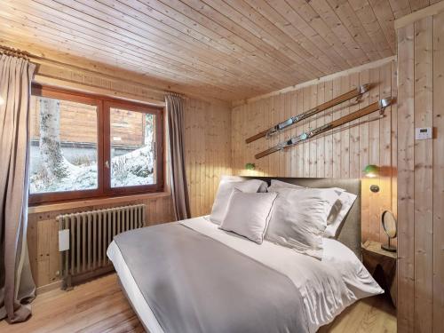 谷雪维尔Chalet Courchevel 1850, 4 pièces, 4 personnes - FR-1-564-97的木制客房内的一间卧室,配有一张床