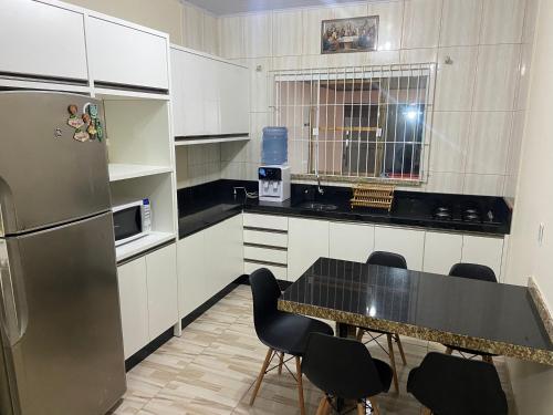 佩尼亚Casa de praia em Penha的厨房配有桌椅和冰箱。