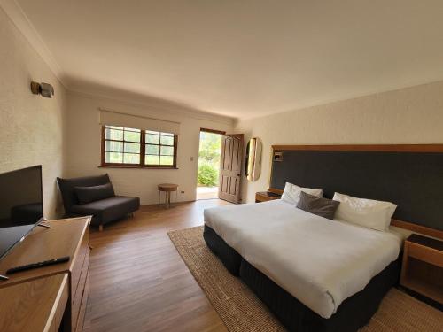 威斯曼菲瑞Wisemans Retreat的酒店客房设有一张大床和一台电视。