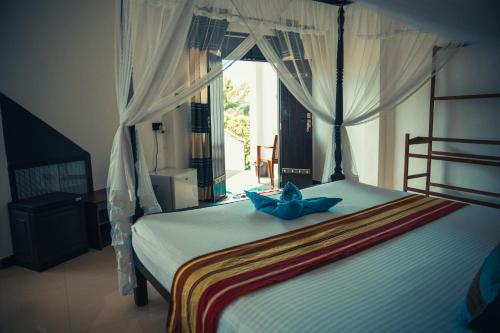 米瑞莎Bisandu guesthouse的一间卧室配有一张蓝色弓床