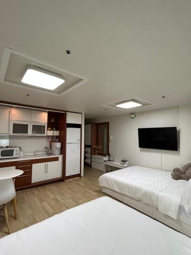 首尔If House Hongdae的一间卧室配有一张床,厨房配有电视