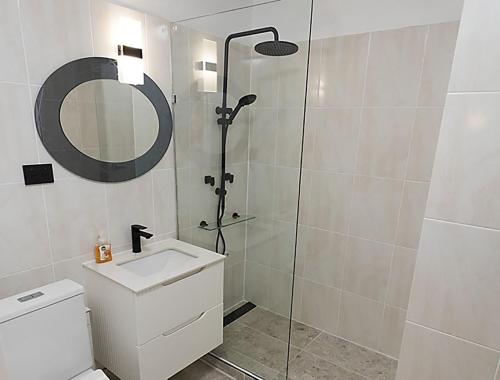 悉尼Location Location Executive Apartment的带淋浴、盥洗盆和镜子的浴室
