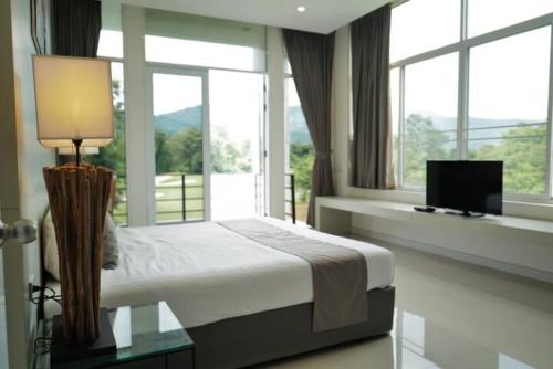 坤西育府Home in Royal Hills Nakhon Nayok的一间卧室设有一张床和一个带电视的窗户。