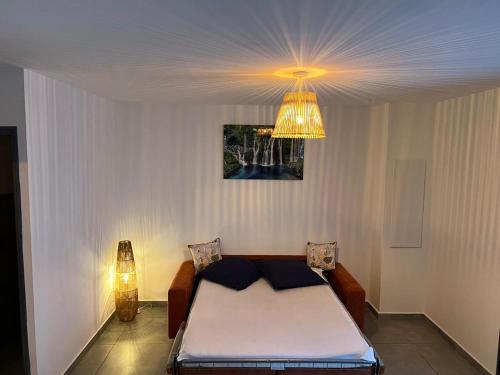 锡拉奥KOM LA KAZ的一间卧室配有一张床和一个吊灯