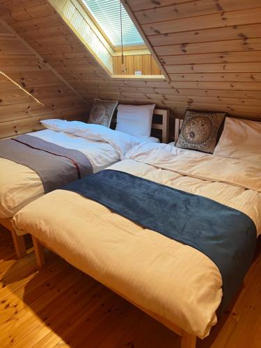 山中湖村山中湖湖畔高級ログハウス 充電富士168的配有2张床的木地板客房