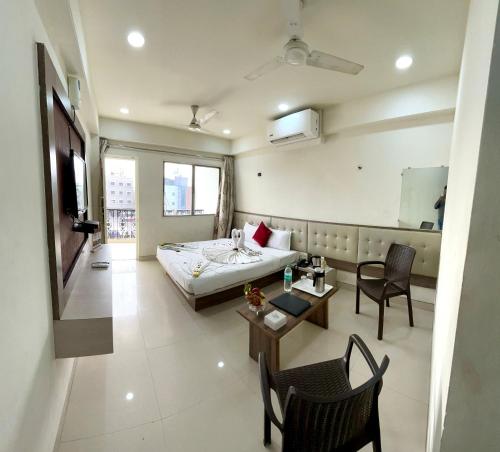 舍地Hotel Sai Chhatra的酒店客房带一张床、一张桌子和椅子
