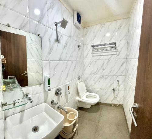 舍地Hotel Sai Chhatra的白色的浴室设有水槽和卫生间。