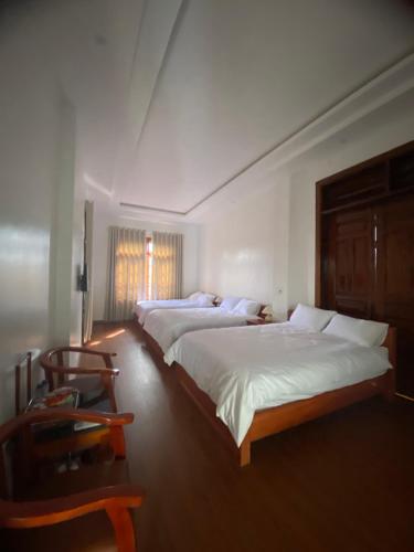 Bắc QuangCao Son Hotel的一间卧室配有两张床和椅子