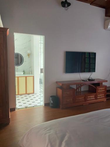 Bắc QuangCao Son Hotel的一间卧室设有平面电视和一张床。