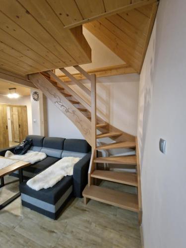 伊斯泰布纳Domek Aniula的带沙发和楼梯的客厅