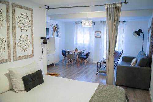 普拉森西亚Apartamentos Suites Cariátide的一间卧室和一间带一张床铺和一张桌子的客厅