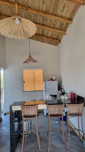 塞古罗港Casinha em Caraíva的厨房配有桌子、两把椅子和天花板