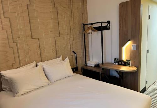 塞尔吉B&B HOTEL Cergy Saint-Christophe Gare的一张带白色床单和枕头的床