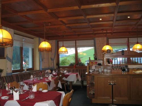伊施格尔Gasthof Talblick的用餐室配有桌椅和吊灯。