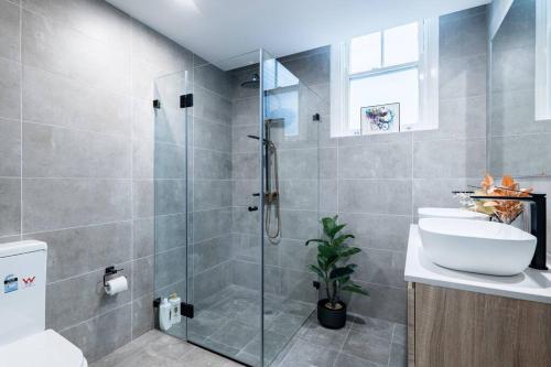悉尼Cozy King Suite Millers Point的一间带玻璃淋浴和水槽的浴室