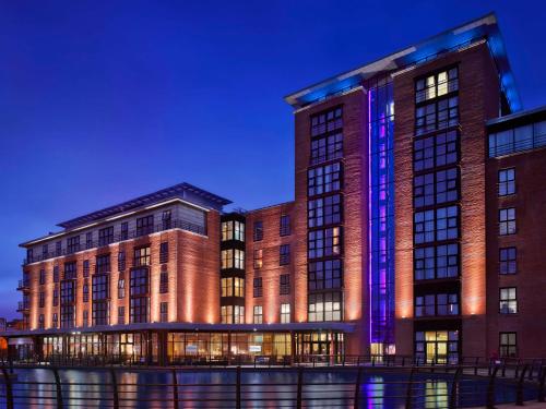 贝尔法斯特The Gasworks Hotel - formerly Radisson Blu Hotel Belfast的建筑的侧面有紫色的灯