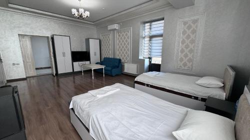 乌尔根奇Parvoz Hotel的酒店客房设有两张床和电视。