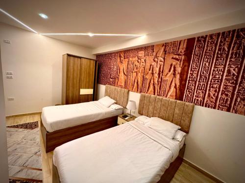 开罗Locanda pyramids view的客房设有两张床和壁画墙