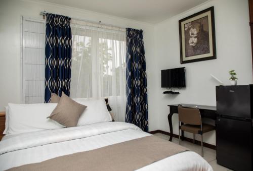 阿克拉Ridge Cozy Rooms的一间卧室配有一张床、一张书桌和一个窗户。