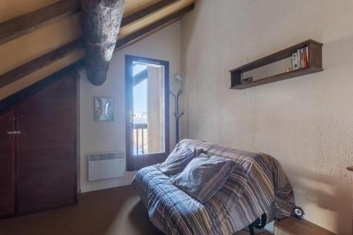 圣雷热雷梅累兹Les Chardons - Apt duplex vue montagne的一间卧室设有一张床和一个窗口