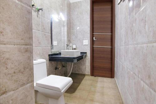 诺伊达Aruba Suites的一间带卫生间和水槽的浴室